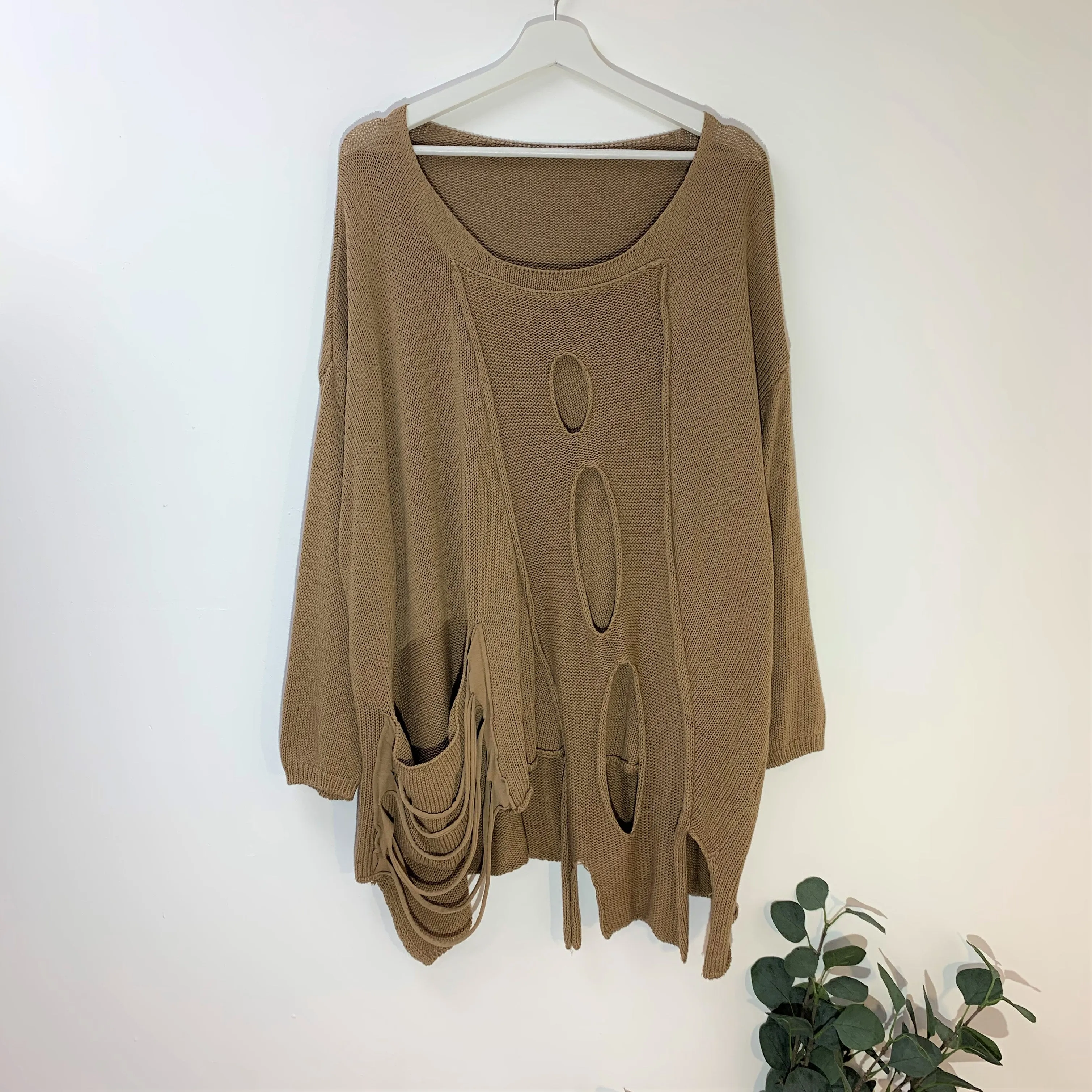 Designer style holey jumper with random hemline
