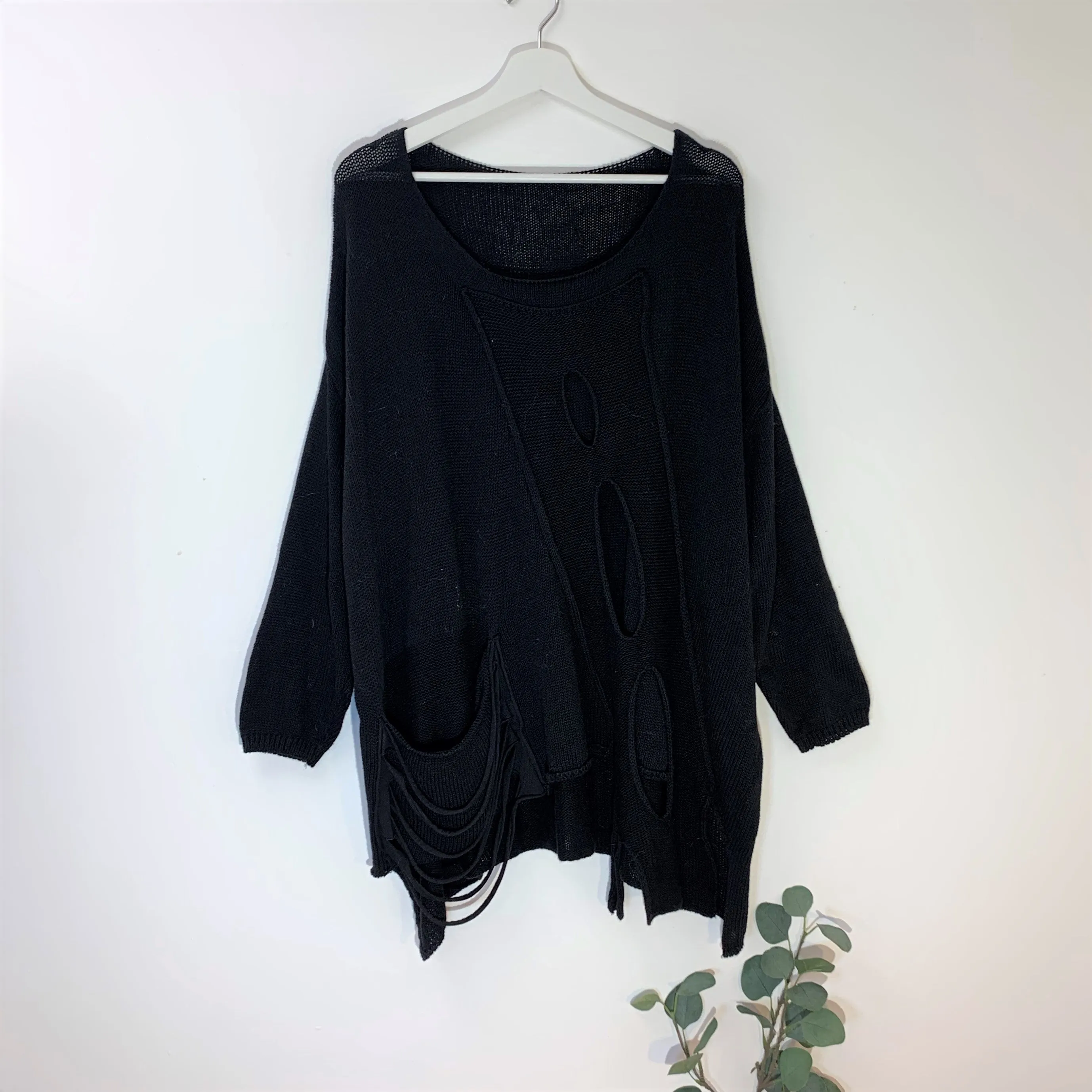 Designer style holey jumper with random hemline